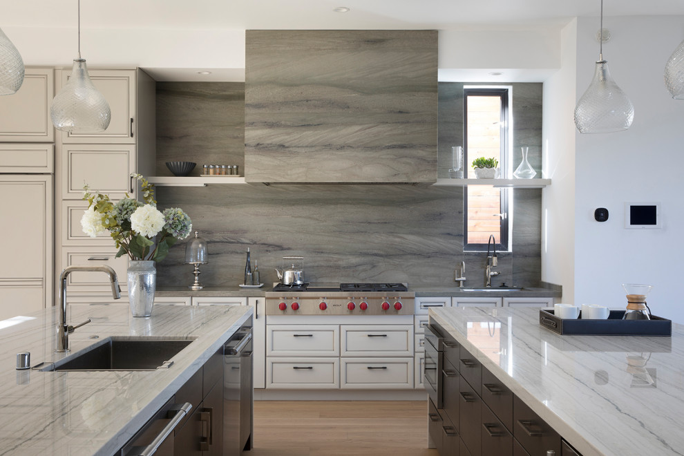 Inspiration for a contemporary kitchen in San Francisco with an undermount sink, raised-panel cabinets, beige cabinets, quartzite benchtops, green splashback, stone slab splashback, stainless steel appliances, light hardwood floors, multiple islands and beige benchtop.