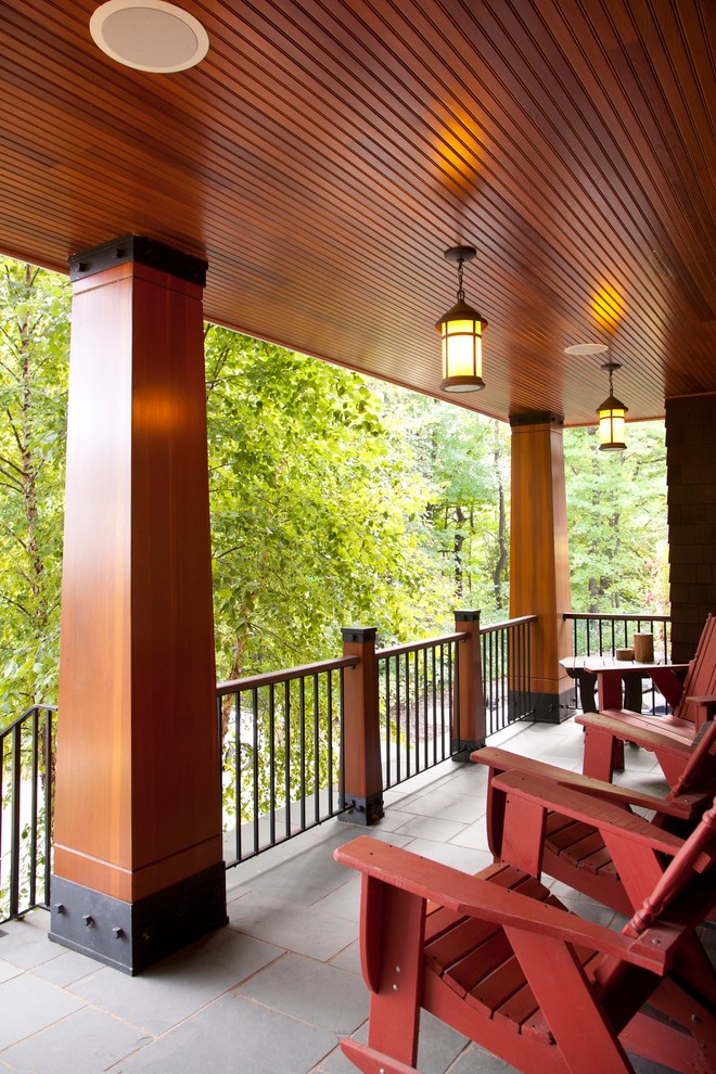 Photo of an expansive beach style front yard verandah in Minneapolis with tile and an awning.