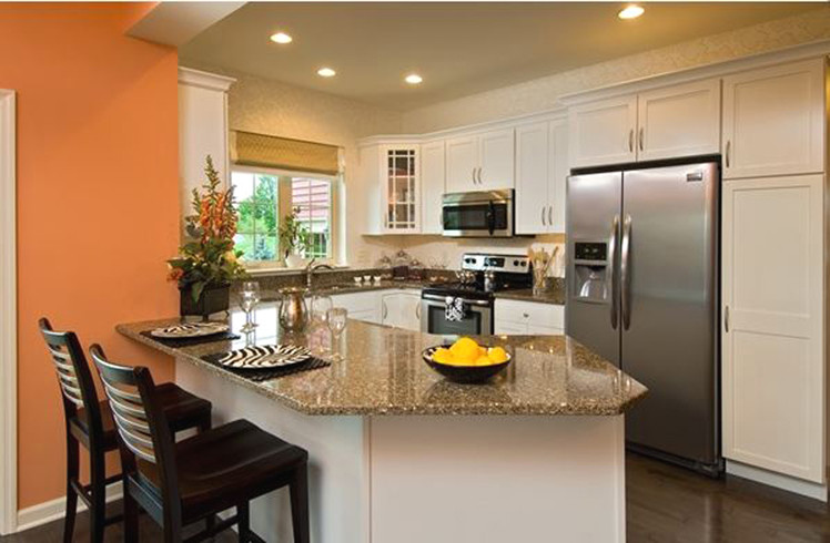 Transitional u-shaped dark wood floor eat-in kitchen photo in Boston with an undermount sink, white cabinets, granite countertops, stainless steel appliances and an island