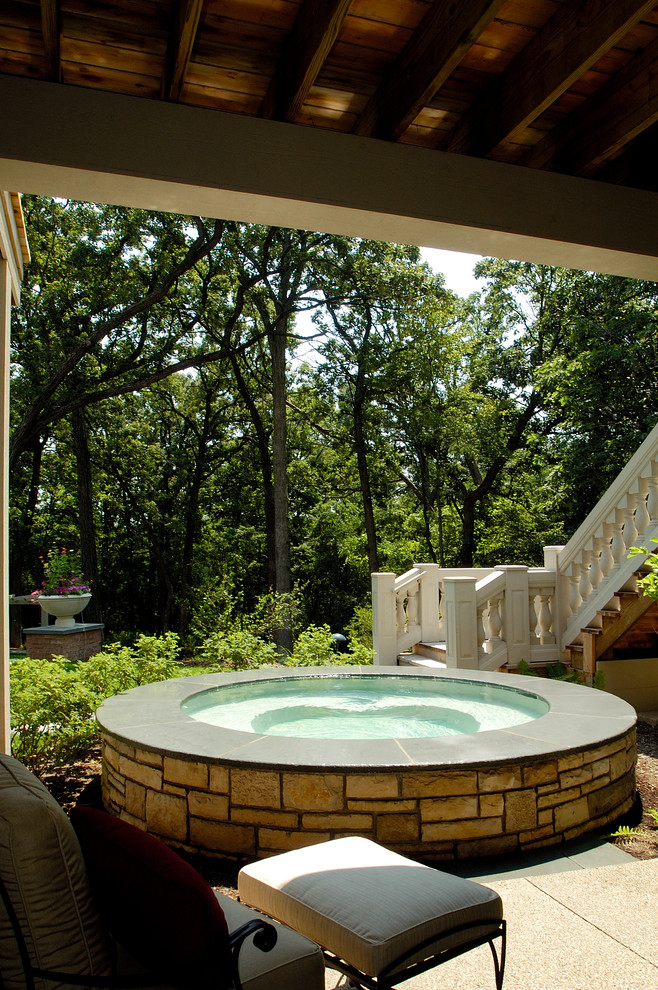 Photo of a small traditional backyard round pool in Chicago with a hot tub.