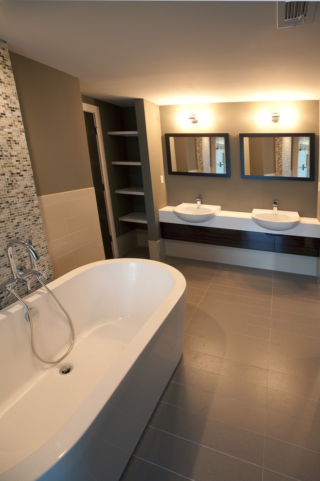 This is an example of a contemporary bathroom in Atlanta with a freestanding tub and mosaic tile.