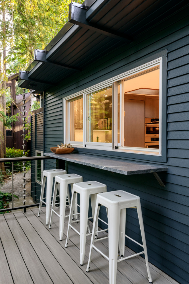 This is an example of a midcentury deck in Seattle with cable railing.
