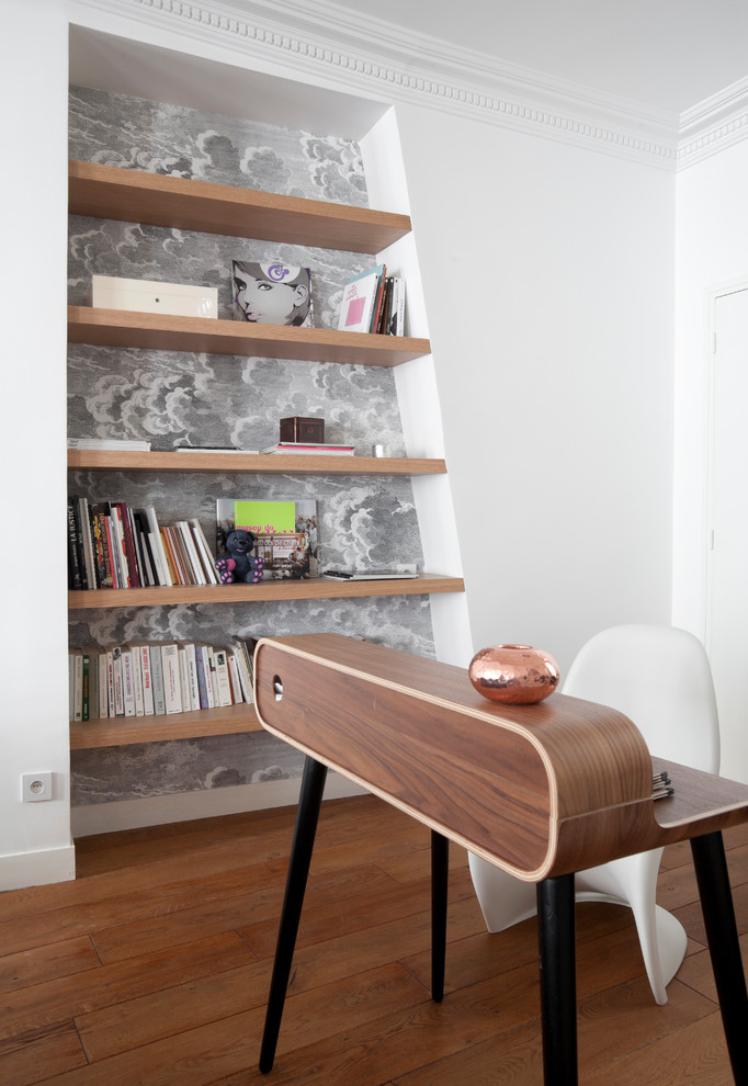 This is an example of a mid-sized contemporary study room in Paris with a freestanding desk, white walls and medium hardwood floors.