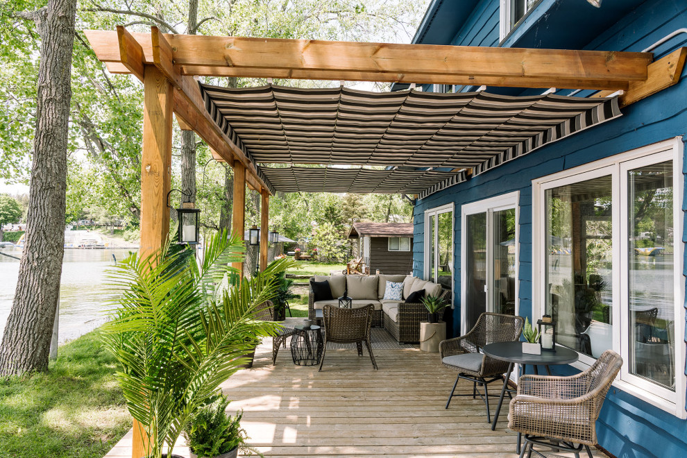 This is an example of a beach style backyard verandah in Toronto with decking and a pergola.
