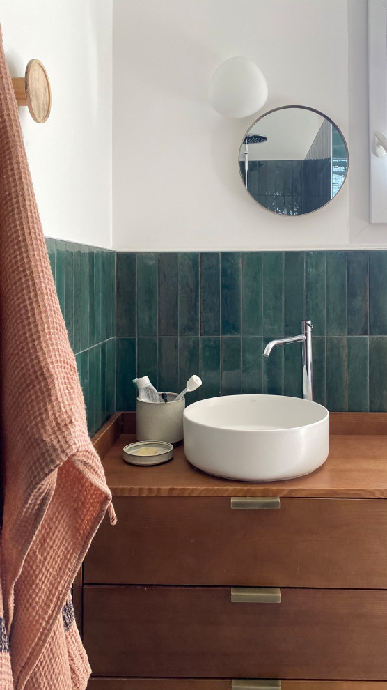 Inredning av ett modernt mellanstort flerfärgad flerfärgat badrum med dusch, med bruna skåp, en kantlös dusch, grön kakel, vita väggar, cementgolv, ett nedsänkt handfat, träbänkskiva, beiget golv och med dusch som är öppen