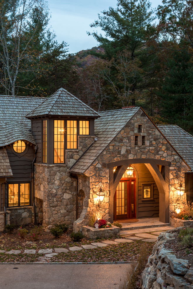 Country two-storey exterior in Other with stone veneer.