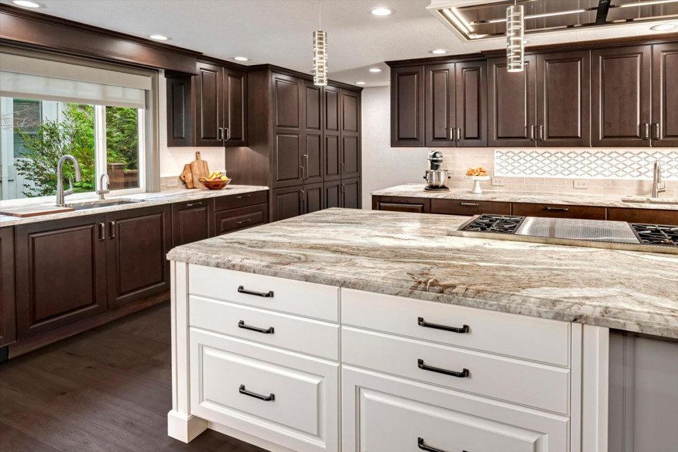 Huge transitional l-shaped medium tone wood floor and brown floor open concept kitchen photo in Seattle with an undermount sink, raised-panel cabinets, brown cabinets, quartzite countertops, beige backsplash, porcelain backsplash, stainless steel appliances, an island and multicolored countertops