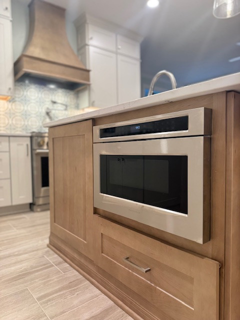 Example of a mid-sized transitional l-shaped porcelain tile eat-in kitchen design with an undermount sink, recessed-panel cabinets, beige cabinets, quartz countertops, stainless steel appliances, an island and white countertops