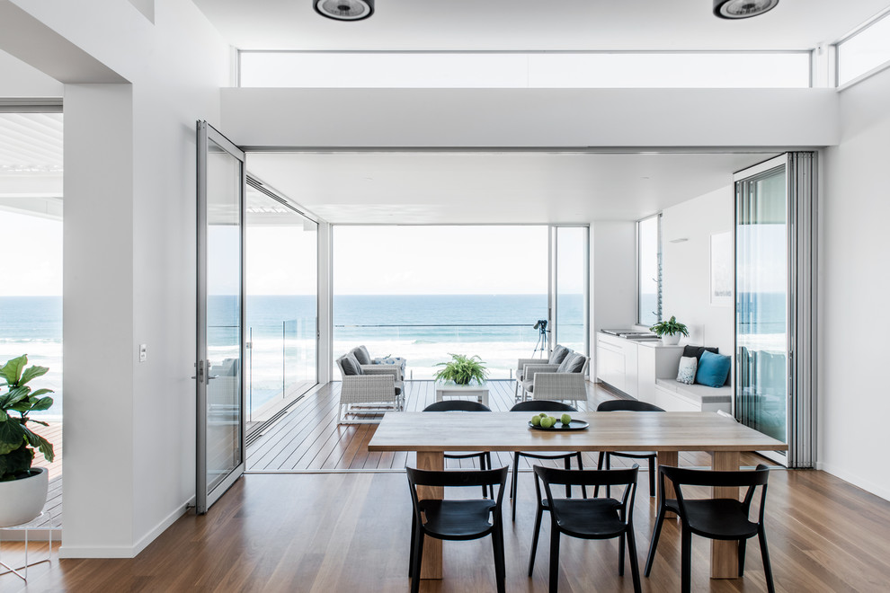 Inspiration for a contemporary dining room in Sunshine Coast with white walls, dark hardwood floors and brown floor.