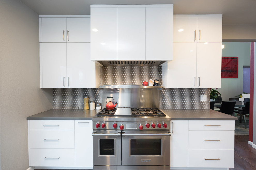 Inspiration for a contemporary porcelain tile and brown floor kitchen remodel with flat-panel cabinets, white cabinets, gray backsplash, stainless steel appliances and an island