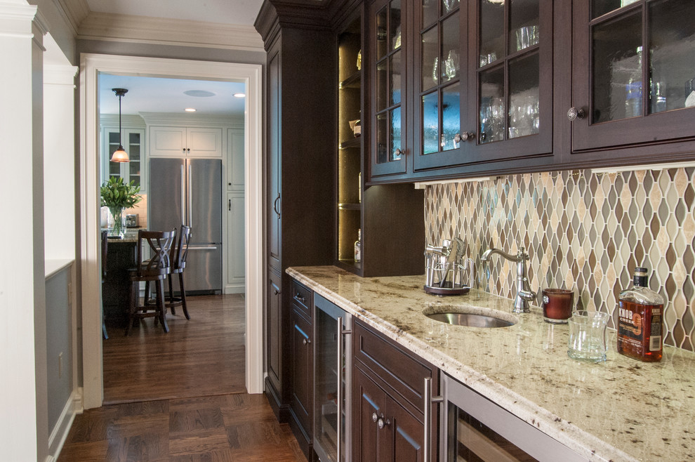 Photo of a mid-sized traditional galley wet bar in Philadelphia with an undermount sink, beaded inset cabinets, dark wood cabinets, granite benchtops, multi-coloured splashback, glass tile splashback and medium hardwood floors.