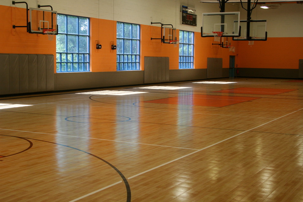 This is an example of a mid-sized traditional indoor sport court in Boston with light hardwood floors and orange walls.