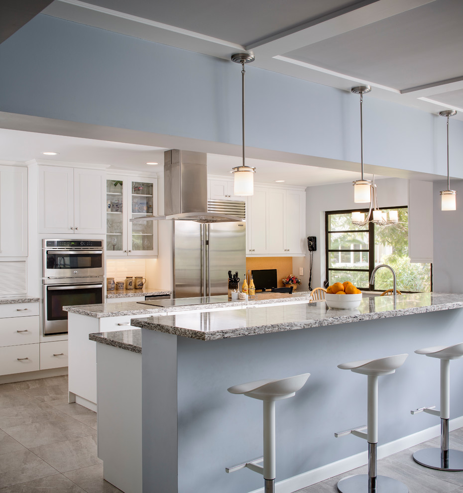 Inspiration for a large transitional u-shaped porcelain tile and gray floor eat-in kitchen remodel in Miami with an undermount sink, shaker cabinets, white cabinets, quartz countertops, white backsplash, subway tile backsplash, stainless steel appliances and an island
