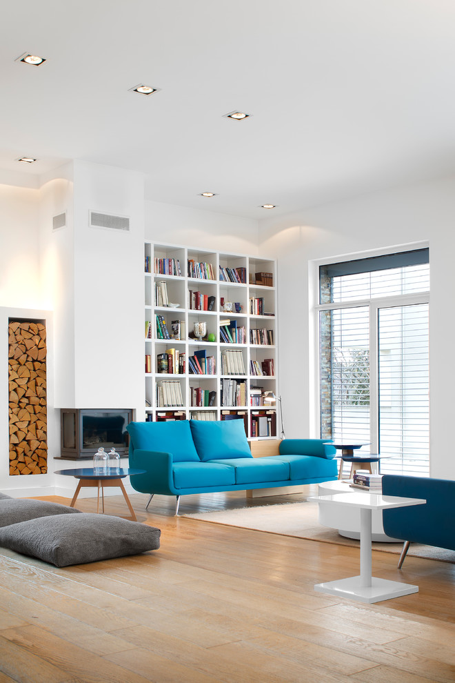 Contemporary living room in Other with light hardwood floors and a library.