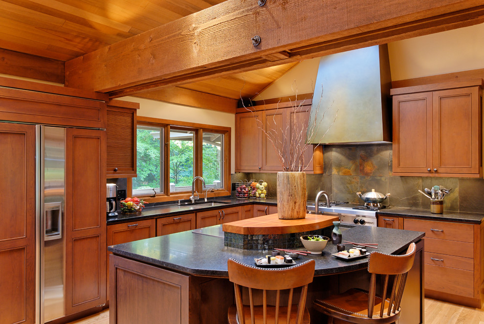 This is an example of a traditional l-shaped open plan kitchen in Seattle with an undermount sink, recessed-panel cabinets, medium wood cabinets, grey splashback and panelled appliances.