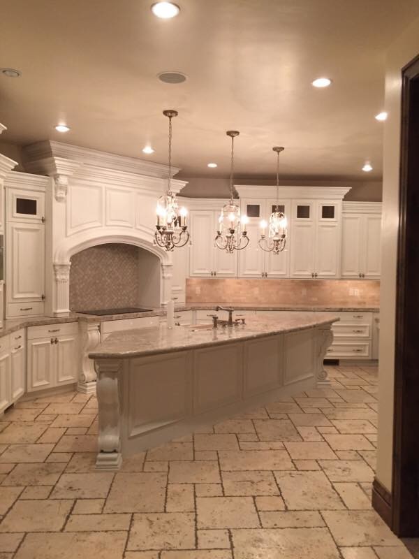This is an example of an expansive traditional l-shaped separate kitchen in Orange County with an undermount sink, raised-panel cabinets, white cabinets, limestone benchtops, beige splashback, stone tile splashback, panelled appliances, brick floors and with island.