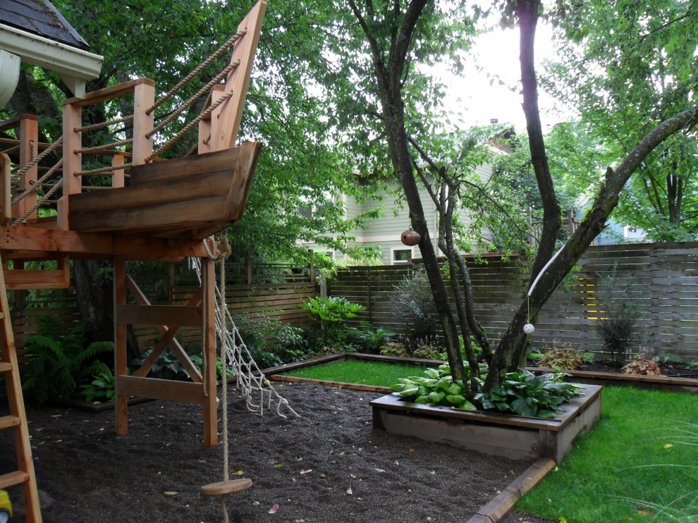 Kleiner, Schattiger Landhausstil Garten hinter dem Haus mit Spielgerät, Flusssteinen und Holzzaun in Portland