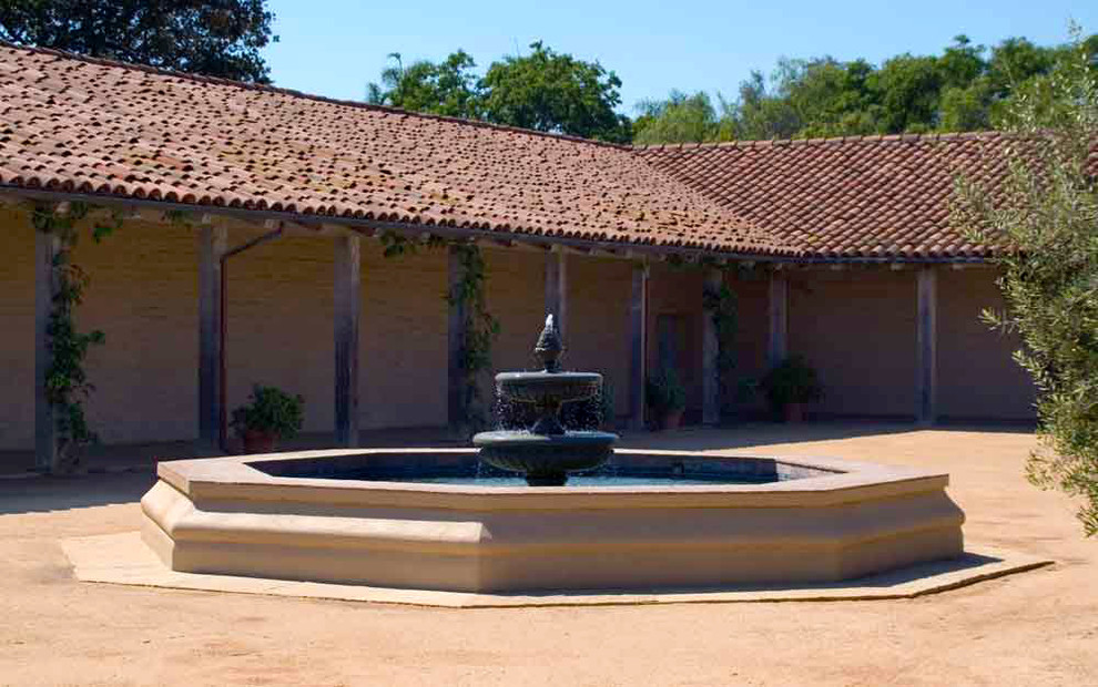 Inspiration for a large courtyard full sun formal garden for summer in Santa Barbara with a water feature and natural stone pavers.