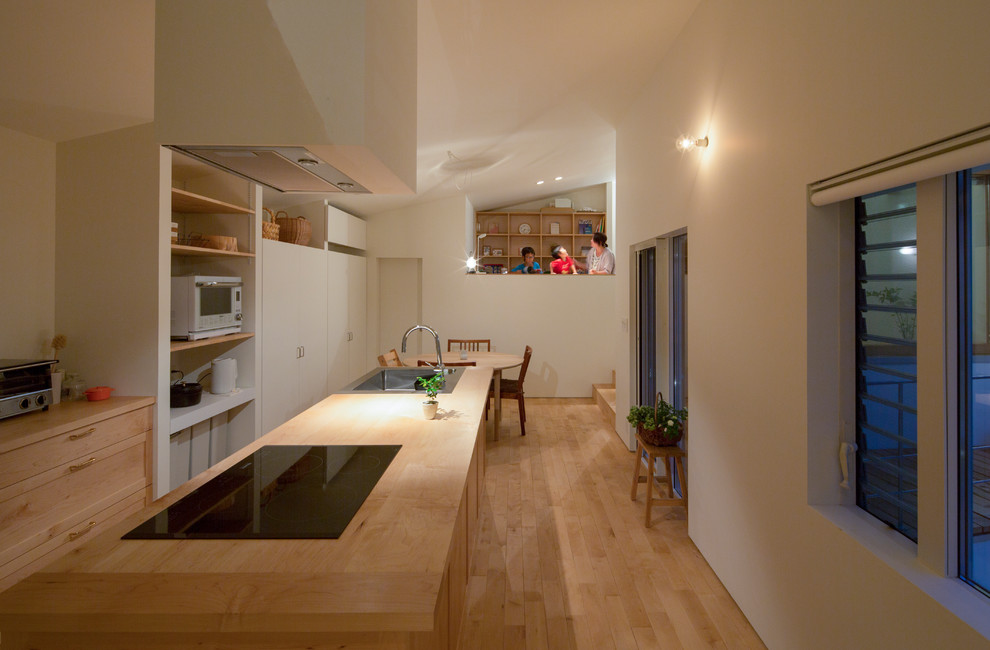 Mid-sized modern galley separate kitchen in Nagoya with an integrated sink, shaker cabinets, light wood cabinets, wood benchtops, white splashback, shiplap splashback, white appliances, light hardwood floors, with island, beige floor and beige benchtop.
