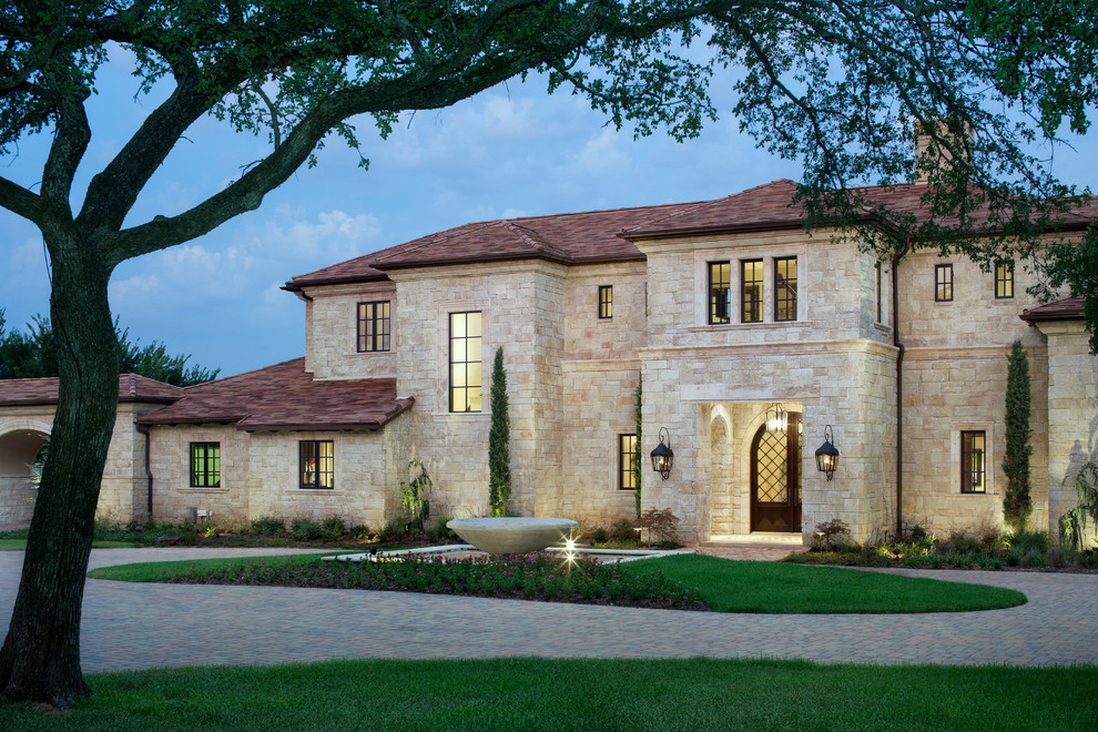 Inspiration for a mediterranean two-storey beige exterior in Austin with stone veneer.