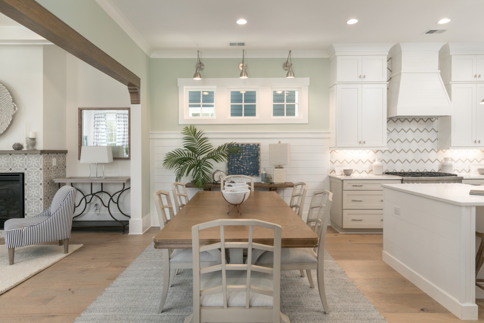 Beach style kitchen/dining room in Charleston with green walls, light hardwood flooring, a tiled fireplace surround and tongue and groove walls.