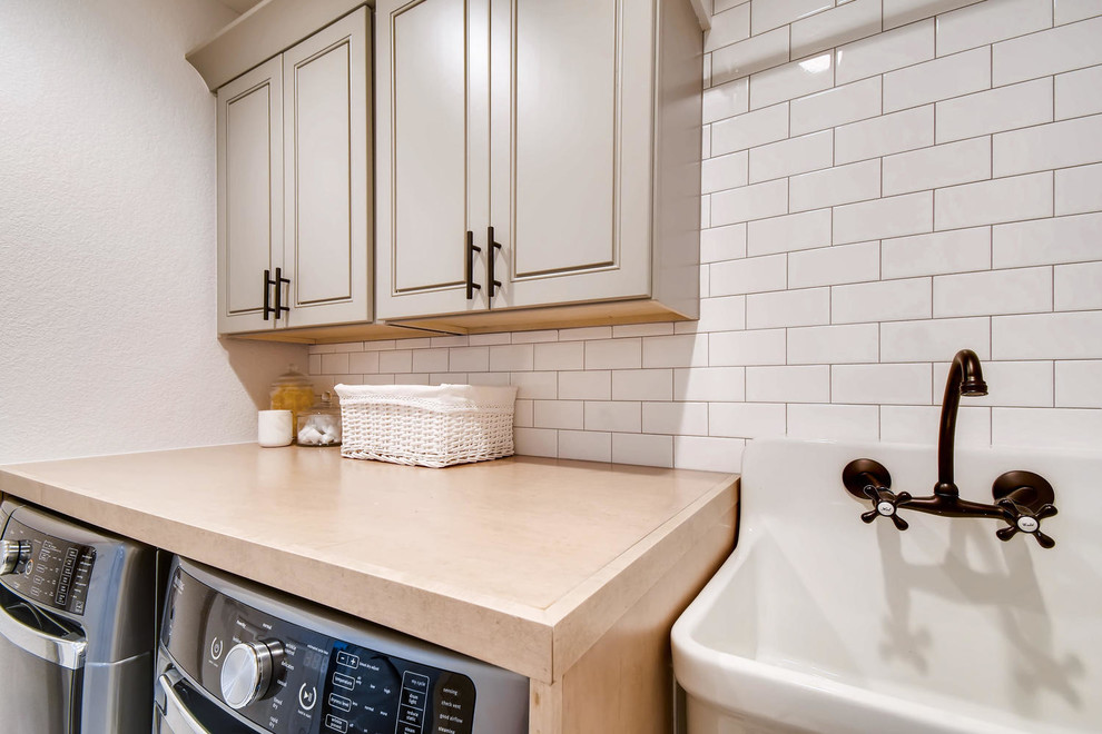 Large country galley dedicated laundry room in Denver with a single-bowl sink, shaker cabinets, beige cabinets, wood benchtops, white walls, ceramic floors, a side-by-side washer and dryer, multi-coloured floor and brown benchtop.