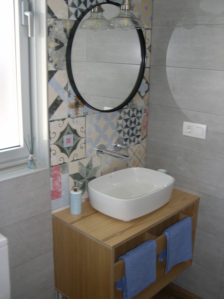 Design ideas for a small country powder room in Other with flat-panel cabinets, light wood cabinets and a vessel sink.