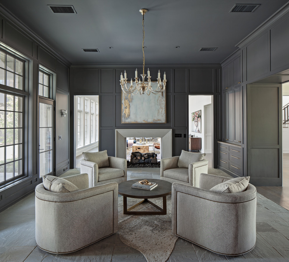 Inspiration for a large transitional formal enclosed living room in Houston with grey walls, a two-sided fireplace, a plaster fireplace surround, grey floor and decorative wall panelling.