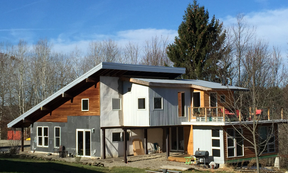 Example of a small eclectic multicolored two-story mixed siding exterior home design in New York with a shed roof and a metal roof