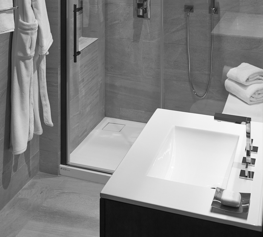 Photo of a small modern master bathroom in Chicago with furniture-like cabinets, dark wood cabinets, gray tile, a freestanding tub, a curbless shower, a one-piece toilet, grey walls, ceramic floors, ceramic tile and an integrated sink.