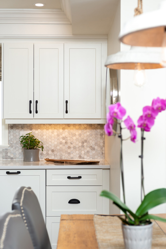 Inspiration for a transitional dark wood floor and brown floor kitchen remodel with white cabinets, quartz countertops, paneled appliances, an island and white countertops