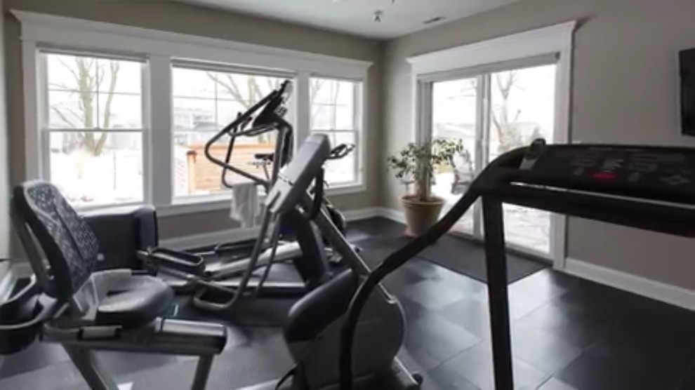 This is an example of a mid-sized transitional home weight room in Other with beige walls and black floor.