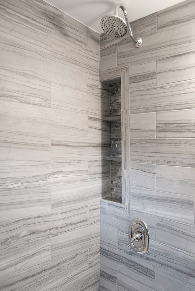 Cette photo montre une salle de bain tendance avec un carrelage gris, des carreaux de porcelaine et une niche.