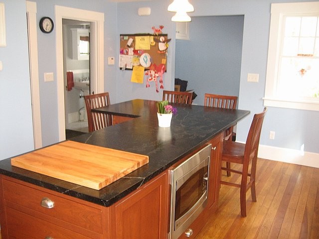 Transitional medium tone wood floor kitchen photo in Boston with medium tone wood cabinets, stainless steel appliances and an island