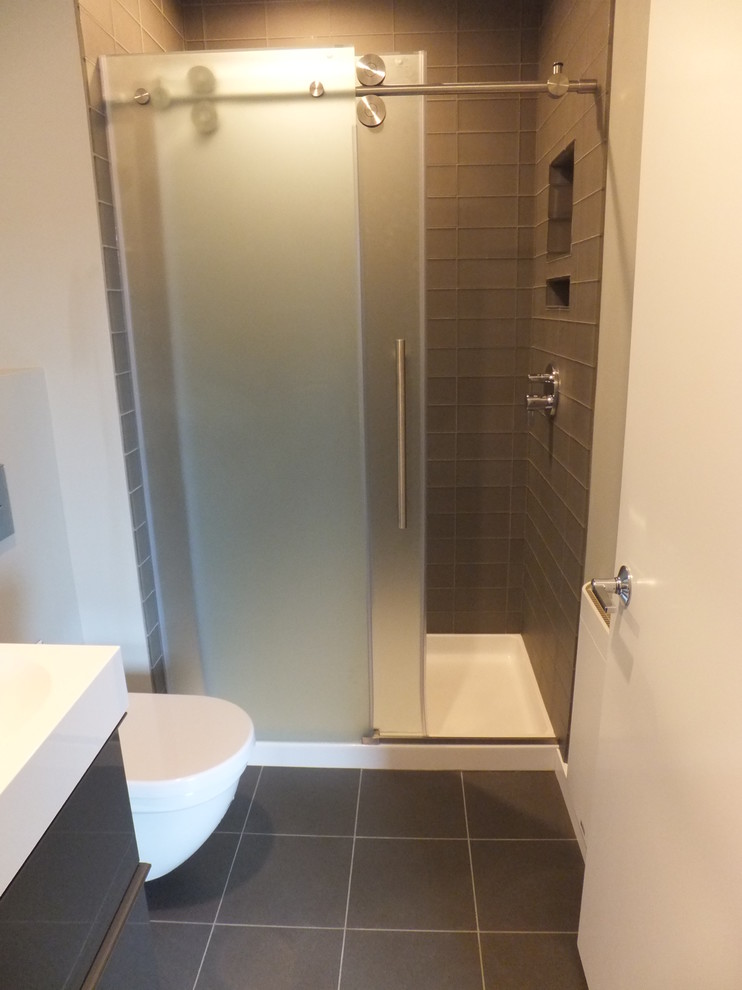 Mid-sized contemporary 3/4 bathroom in Orange County with flat-panel cabinets, brown cabinets, an alcove shower, a one-piece toilet, grey walls, ceramic floors, quartzite benchtops, gray tile, glass tile, grey floor and a sliding shower screen.