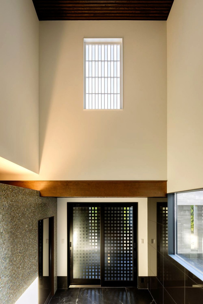 神戸にあるラグジュアリーな巨大なトランジショナルスタイルのおしゃれな玄関 (白い壁、セラミックタイルの床、黒いドア、黒い床、格子天井、壁紙、黒い天井) の写真