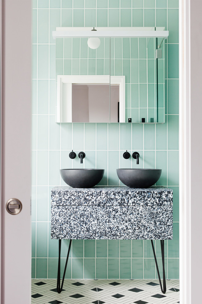 This is an example of a mid-sized contemporary bathroom in London with a vessel sink, green tile, ceramic tile, green walls and multi-coloured floor.