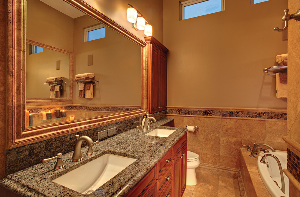 Design ideas for a mid-sized traditional master bathroom in Chicago with raised-panel cabinets, medium wood cabinets, a drop-in tub, beige tile, beige walls, an undermount sink and granite benchtops.