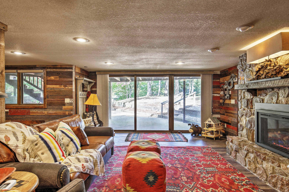 Inspiration for a mid-sized rustic walk-out vinyl floor and brown floor basement remodel with multicolored walls, a standard fireplace and a metal fireplace