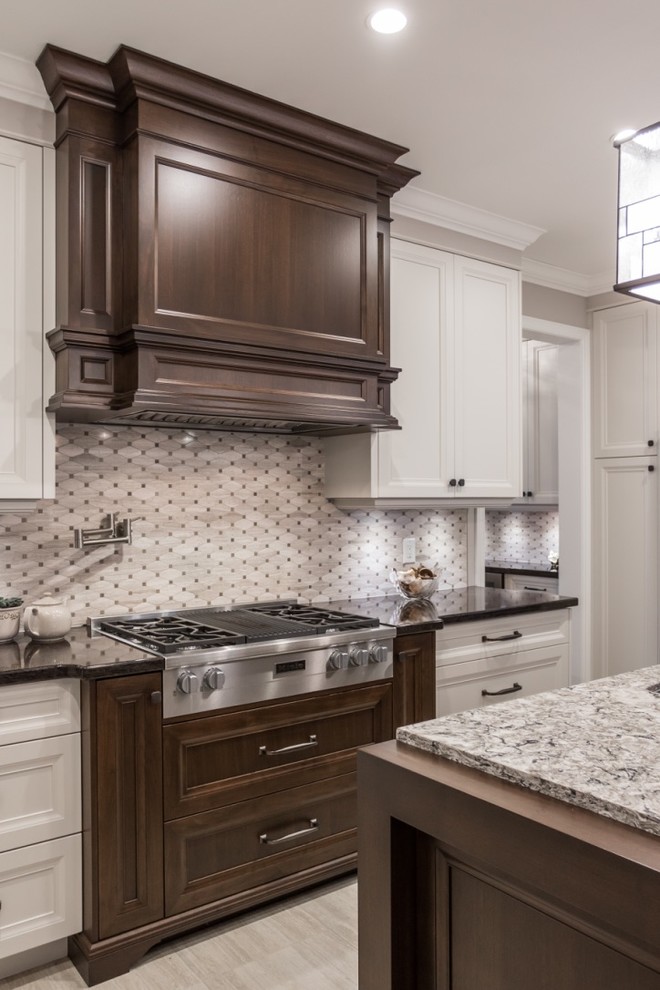 Eat-in kitchen - mid-sized transitional l-shaped ceramic tile eat-in kitchen idea in Toronto with an undermount sink, shaker cabinets, granite countertops, mosaic tile backsplash, stainless steel appliances, an island, gray backsplash and white cabinets