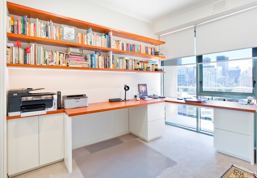 Photo of a mid-sized contemporary study room in Melbourne with a built-in desk, white walls, carpet and no fireplace.
