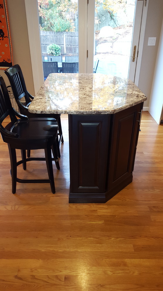 Eat-in kitchen - large transitional l-shaped light wood floor eat-in kitchen idea in Boston with an undermount sink, raised-panel cabinets, white cabinets, granite countertops, gray backsplash, ceramic backsplash, stainless steel appliances and an island