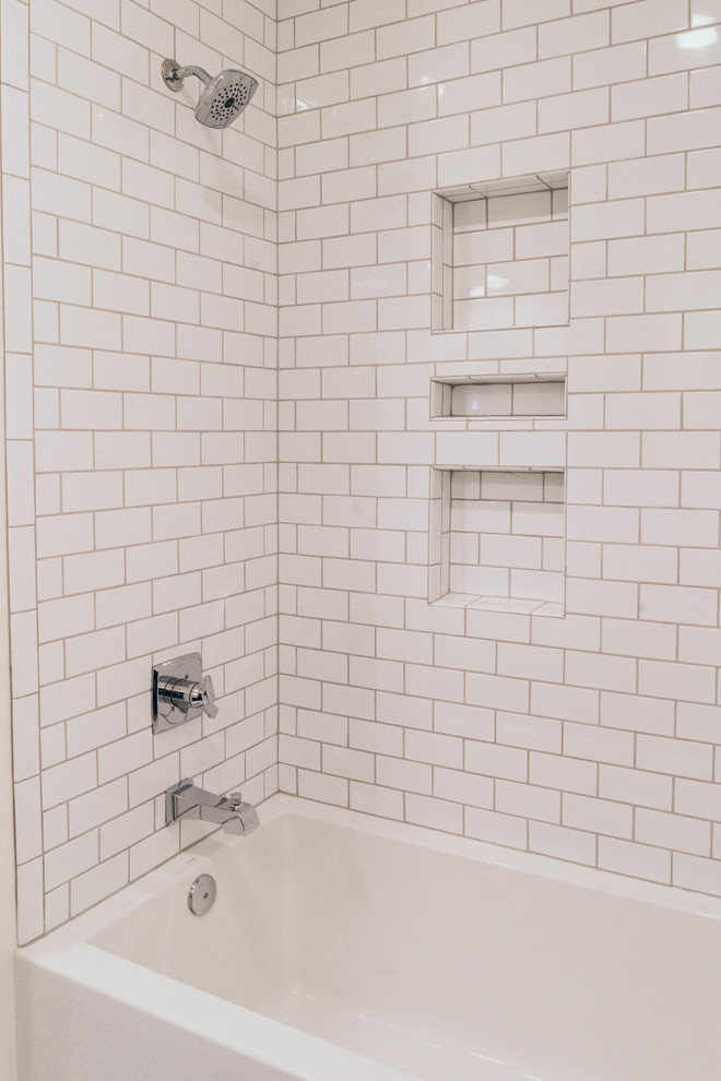 Inspiration for a transitional kids' white tile alcove bathtub remodel in Omaha with shaker cabinets, white cabinets, a two-piece toilet, an undermount sink, quartz countertops and white countertops