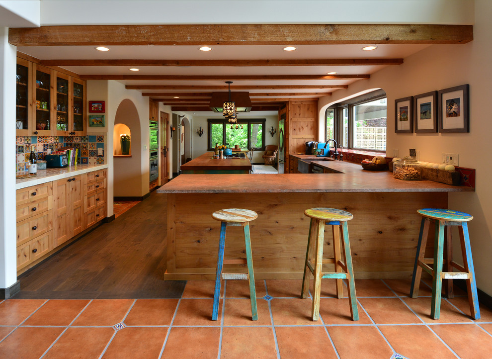This is an example of a large l-shaped open plan kitchen in Seattle with a farmhouse sink, recessed-panel cabinets, turquoise cabinets, wood benchtops, multi-coloured splashback, ceramic splashback, stainless steel appliances, medium hardwood floors, with island and brown floor.