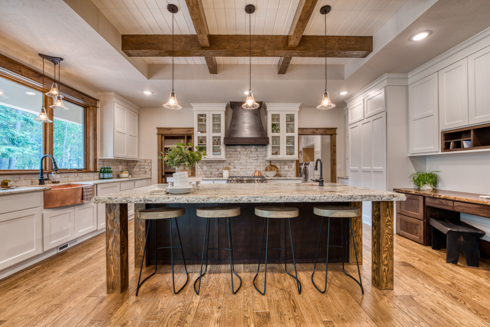 Example of a mountain style u-shaped medium tone wood floor, brown floor, exposed beam and shiplap ceiling kitchen design with a farmhouse sink, shaker cabinets, white cabinets, paneled appliances, an island and gray countertops