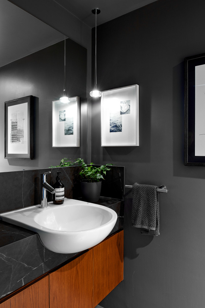 Inspiration for a mid-sized contemporary 3/4 bathroom in Brisbane with flat-panel cabinets, medium wood cabinets, grey walls, an integrated sink and black benchtops.
