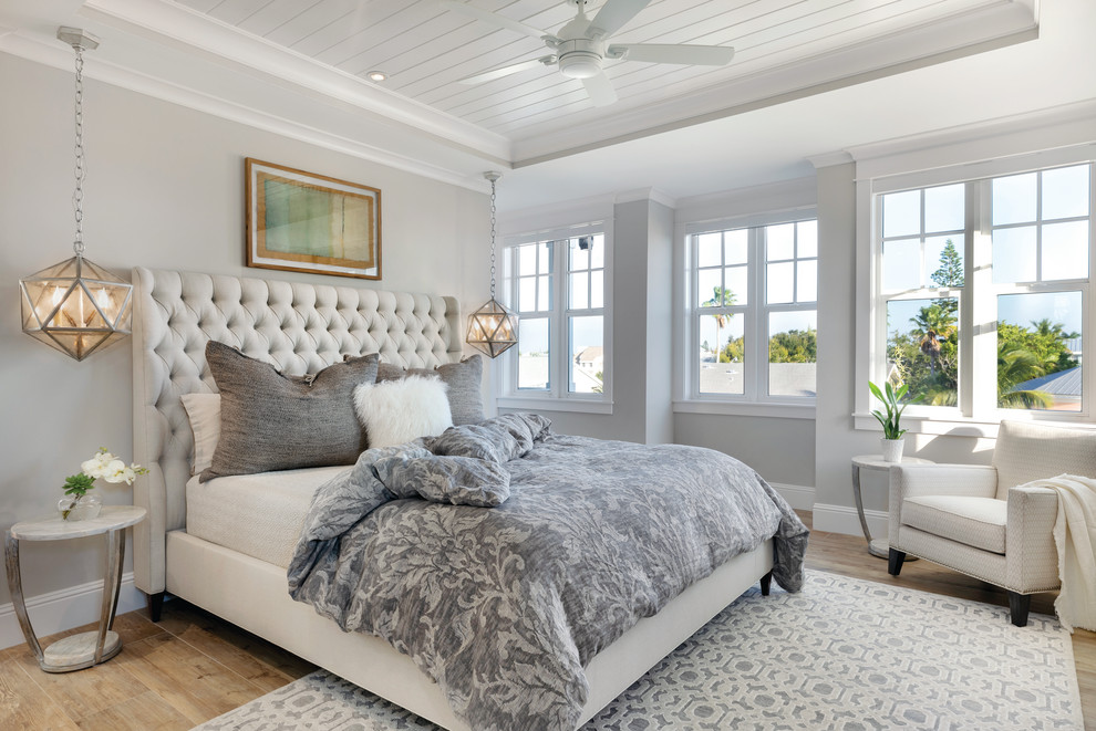 Mid-sized beach style master bedroom in Tampa with beige walls, ceramic floors, no fireplace and beige floor.