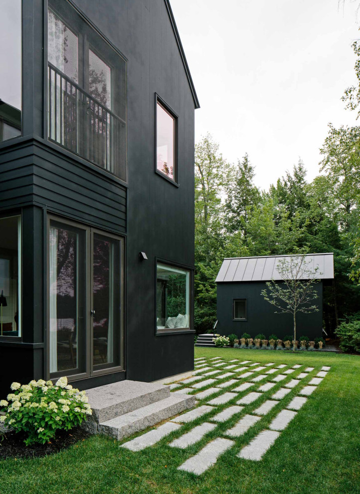 Ispirazione per la villa nera rustica a due piani con rivestimento in legno, tetto a capanna, copertura in metallo o lamiera e tetto nero