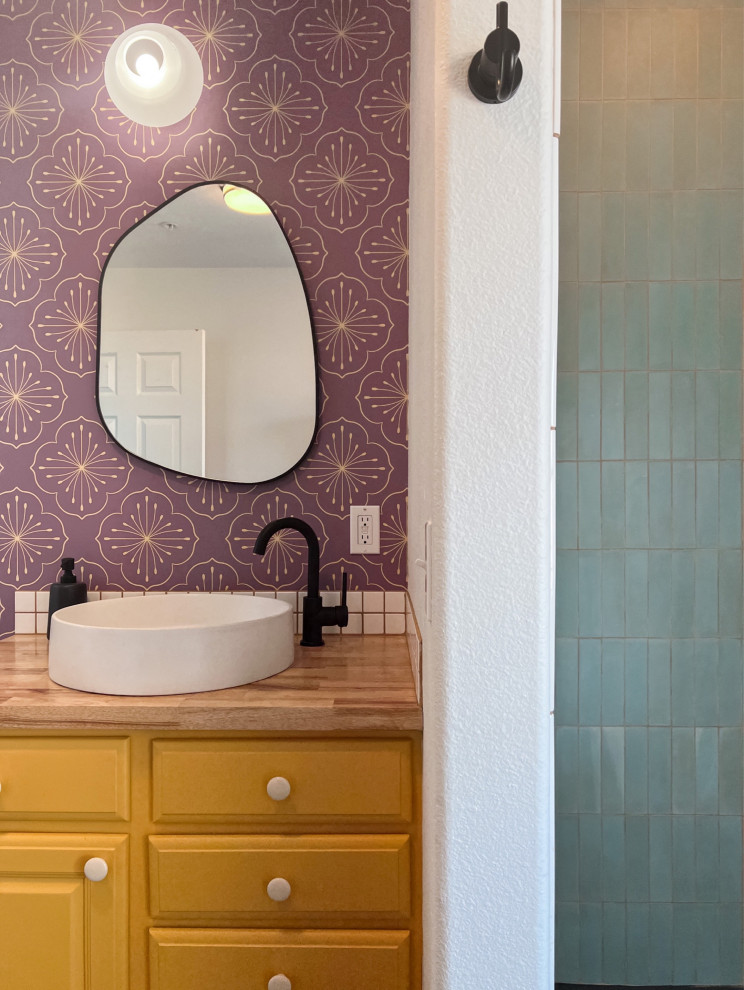 Inredning av ett modernt brun brunt badrum, med luckor med upphöjd panel, gula skåp, en hörndusch, blå kakel, cementkakel, vita väggar, skiffergolv, ett fristående handfat, träbänkskiva, svart golv och dusch med duschdraperi