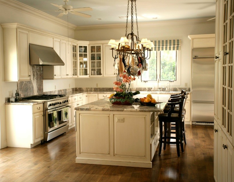 Inspiration for a large transitional l-shaped medium tone wood floor kitchen remodel in Miami with a drop-in sink, glass-front cabinets, distressed cabinets, marble countertops, stainless steel appliances, multicolored backsplash, stone slab backsplash and an island